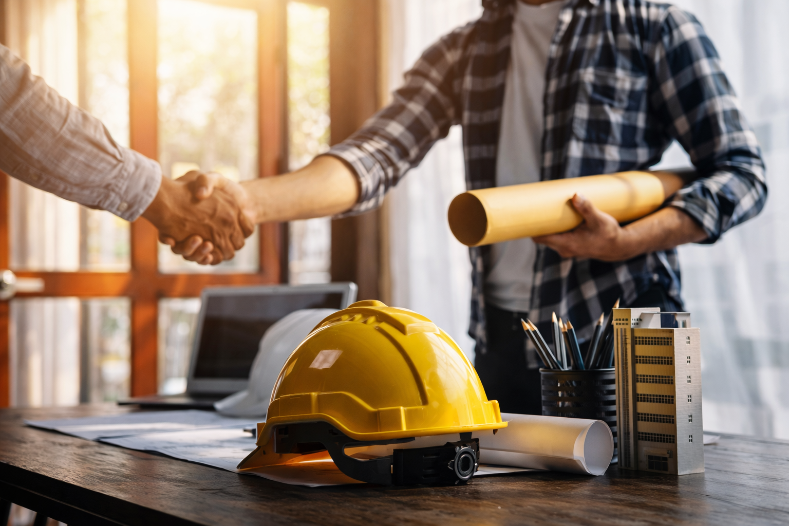 Contractor shaking hands with a client over project plans